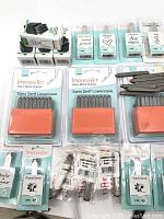 Several sets of ImpressArt metal stamps laid out, including Basic Metal Stamps packaging for lowercase letters and design symbols.
