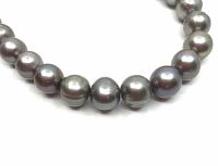 Close-up of several pearls showing silver grey color with peacock sheen and round shape