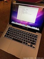 Open MacBook Pro showing desktop and backlit keyboard
