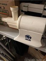 White Champion brand juicer machine with feed tube and funnel attached, showing logo and general body condition.