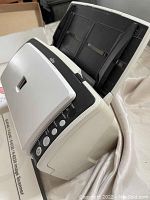 Front angled view showing scanner feeder, controls, and control panel on right side with buttons and indicators