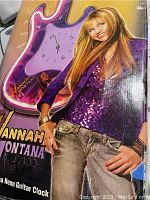 Box front showing Hannah Montana image and neon guitar clock image with clock face visible