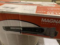 Photo of the Magnavox DVD player box showing front panel image and remote control, with branding and product details on the box.