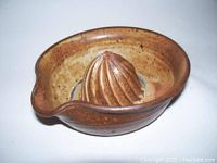 Top view of brown mottled ceramic citrus juicer showing ribbed cone and pour spout