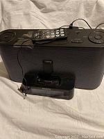 Full view of Sony iPod dock radio speaker unit with control buttons on top, small remote on the unit, and the separate clock radio dock in front