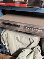 Full view of Sony stereo tuner ST-J55 on shelf with fabric underneath, silver metal body with digital frequency display and preset buttons