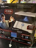 Photo of the front and side of the boxed Star Wars Science The Force Trainer II showing hologram projection feature and Jedi challenges branding.