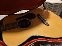 Full guitar body in open case showing spruce top and pickguard