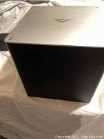 Wireless subwoofer with black body and silver top featuring Vizio logo.