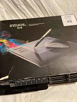 Front of Wacom Intuos 4x6 tablet box showing stylus pen image and colorful graphic effects on box.