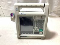 Front view of the infusion pump showing the screen, keypad with numbered and function buttons, and the handle on top.