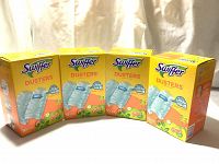 Four sealed boxes of Swiffer Dusters refills arranged side by side, showing front packaging with brand and scent details.