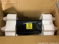 Interior view of box showing the fixing assembly sealed in a black ESD bag and supported by white foam inserts