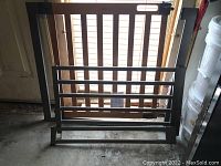 Photo of the Summer Westend child safety gate showing horizontal bars and locking mechanism with wooden slats background.