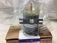 Photo of the transducer on top of the original cardboard box sealed in plastic bag.