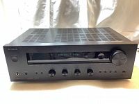 Front view of the Onkyo TX-8050 network stereo receiver powered on showing FM 104.5 MHz on the digital display.