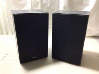 Pair of black Sony SS-S20 speakers with fabric grilles, one with Sony badge and one without.