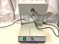 Full view of white tissue culture rotator with metal shaft and front controls.