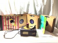 Wide view showing RCA Victor 78 RPM record player and multiple 78 RPM vinyl records in original sleeves including Miss Liberty and Kiss Me Kate
