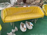 Front angled view showing yellow vinyl upholstery and white metal rocking frame