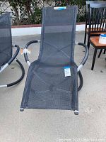 Full front view of the black mesh full motion patio lounger on aluminum curved frame