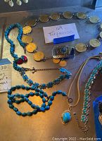 Top overview of assorted turquoise jewelry including necklace with coin medallions, beaded turquoise necklaces, and pendant necklace.