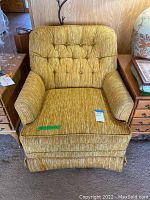 Front view showing the yellow tufted backrest, padded arms and seat cushion.