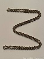 Full-length view of rope chain laid out in S shape against white background