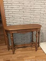 Full frontal view of the antique wood hallway table showing carved apron and turned leg detail