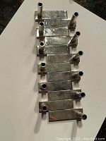 Eight silver-plated place card holders arranged on white background showing full size and shape.