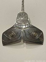 Front view of sterling silver whale tail pendant with gold inlays