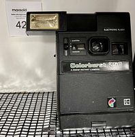Front angled view of Kodak Colorburst 250 instant camera showing electronic flash and exposure adjustment sliders.