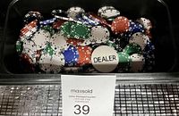 Top view of the poker chips showing multiple colors including white, red, green, and blue, with the larger dealer chip visible on top.