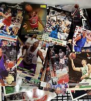 Photo showing a diverse spread of basketball trading cards featuring players like Keith Booth and Dino Radja in action poses, multiple team uniforms visible
