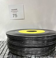 Stack of over 30 vintage 45 RPM records, showing thickness and edges without sleeves