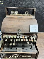 Front view showing keys with various numbers, round buttons indicating price amounts, metal lock, and price display on top.