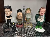 Photo of four bobblehead collectibles: Simon Cowell, Duck Dynasty's Willie and Phil, and The Mayor of Munchland