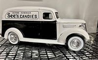 Side view of die-cast black and white 1938 Chevy panel truck model with Sees Candies logo on side