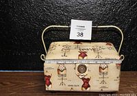 Closed sewing case showing mannequin pattern and button closure.