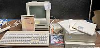 Wide front view showing computer, keyboard, manuals, external drive and mouse