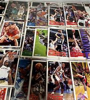 Multiple NBA basketball trading cards shown in double sleeves with visible player images, names, and teams including rookies.