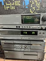 Front view of stacked Mitsubishi stereo components showing controls, digital displays, and brand labeling.