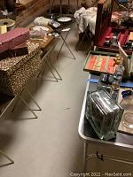 Photo showing four TV tray tables with leopard print tops and a rectangular card table with foldable legs in the background