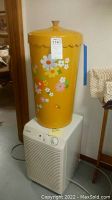Kenmore dehumidifier with large yellow floral tin on top, showing front controls and vents.