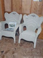 Two white wicker chairs placed side by side, showing the front and top details of the seats and backs.