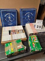Two blue baseball card albums, two trays full of cards, two boxes with sealed card packets visible