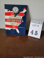 Photo of the blue collector's album for United States Commemorative Statehood Quarters 1999-2003 Volume 1 with U.S. map and flag design.