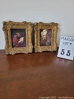 Both framed paintings sitting side by side on a wooden surface showing front view and size comparison.