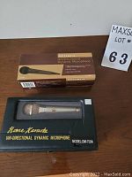 Two boxed microphones displayed on a wooden surface with MaxSold lot number sign.