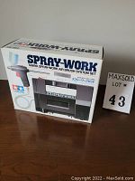 Front of box showing the Tamiya Spray-Work title and image of the air brush gun and compressor unit.